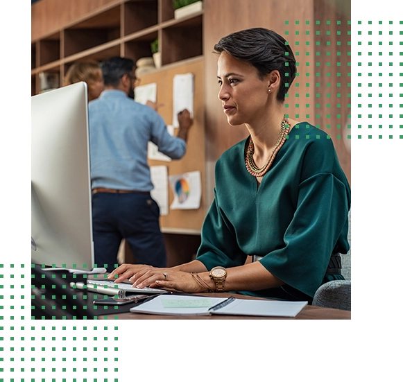 Woman working at a computer with people in the background